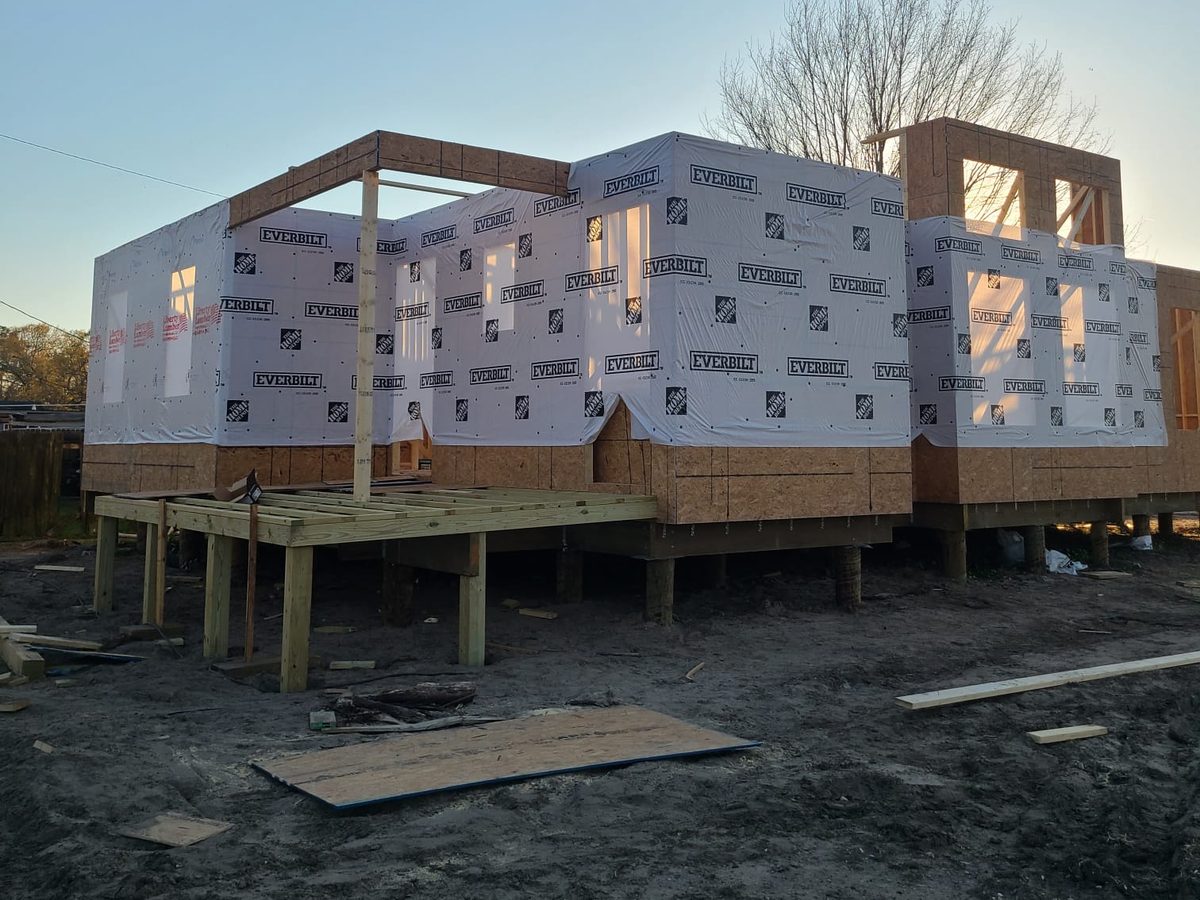 Wrapped raised home with a new porch deck framed on posts