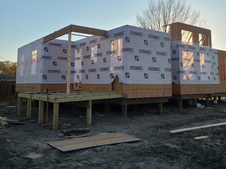 Wrapped raised home with a new porch deck framed on posts