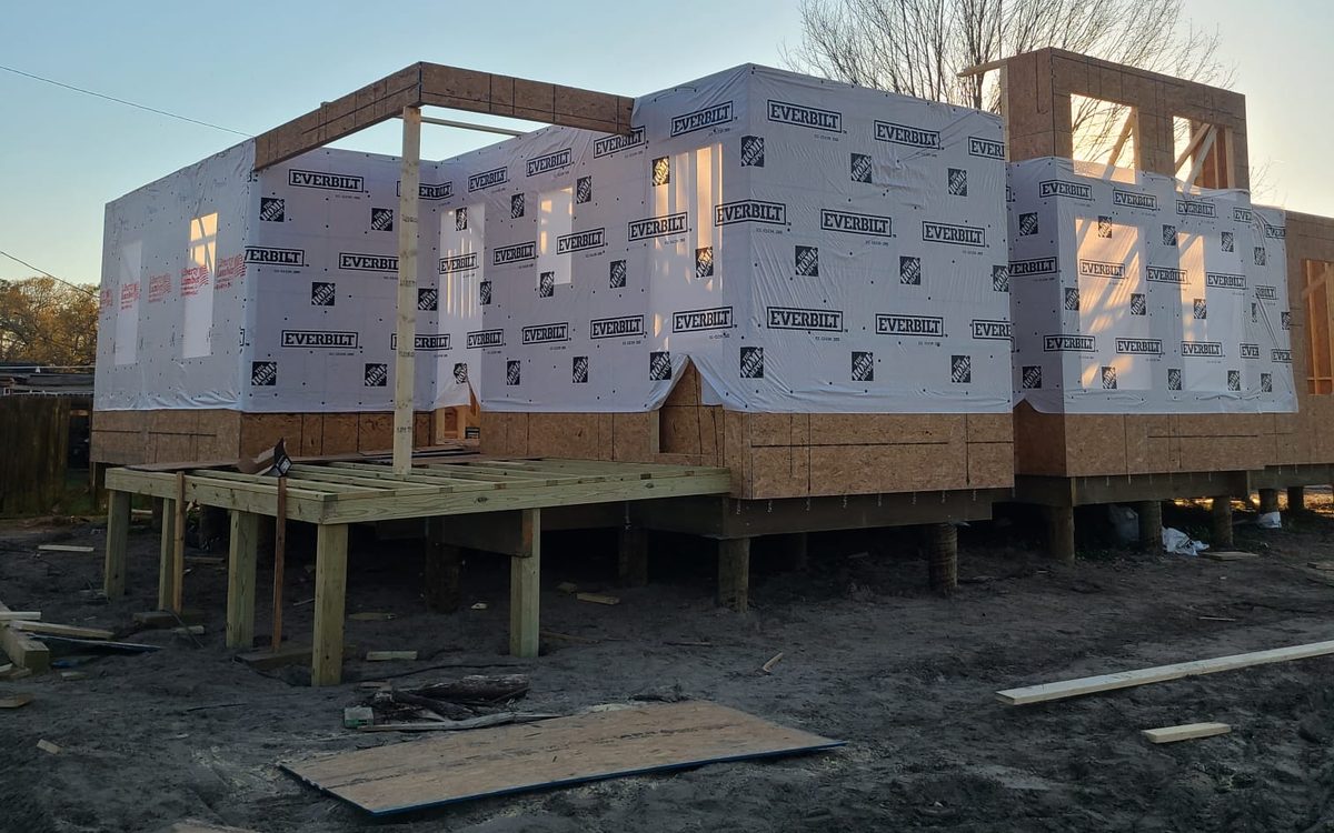 Wrapped raised home with a new porch deck framed on posts