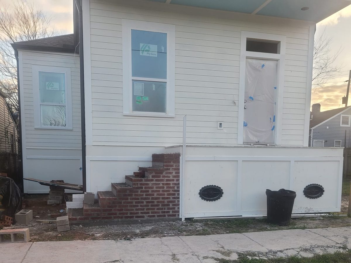 Finished white home with lap siding, trimmed windows and new brick front steps
