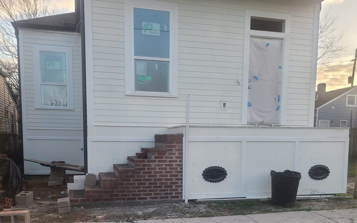 Finished white home with lap siding, trimmed windows and new brick front steps