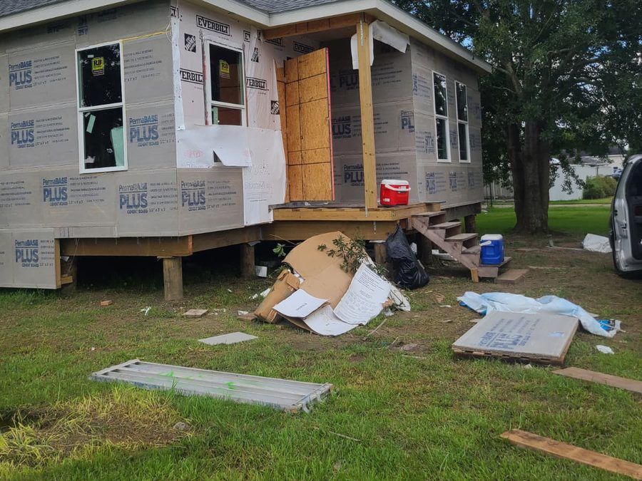 Corner of a home with cement board, new windows and a framed entry porch