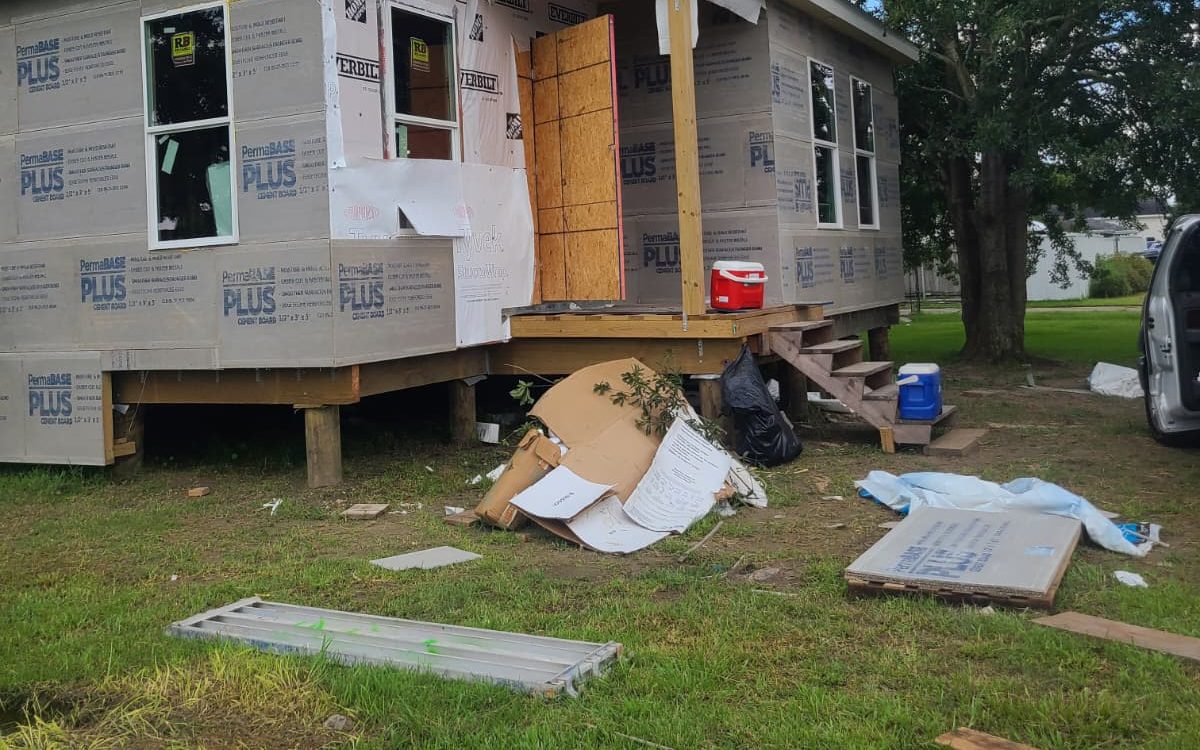 Corner of a home with cement board, new windows and a framed entry porch