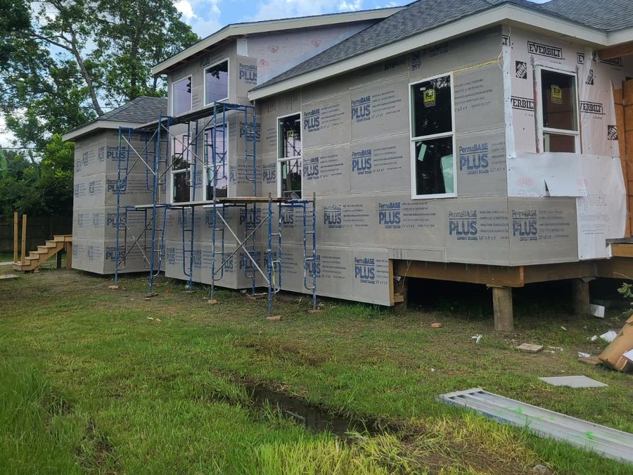 Side of a home with cement board cladding, new windows and scaffolding