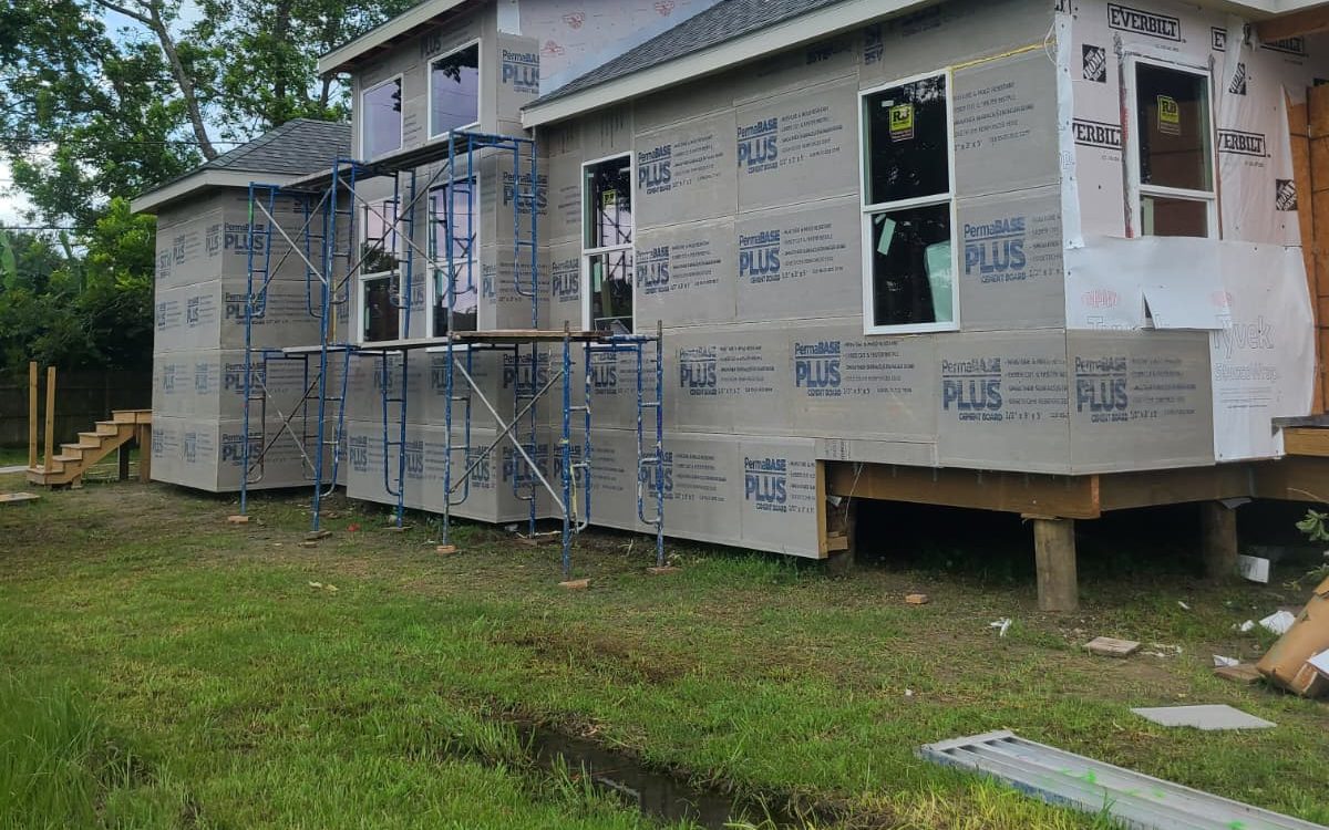 Side of a home with cement board cladding, new windows and scaffolding