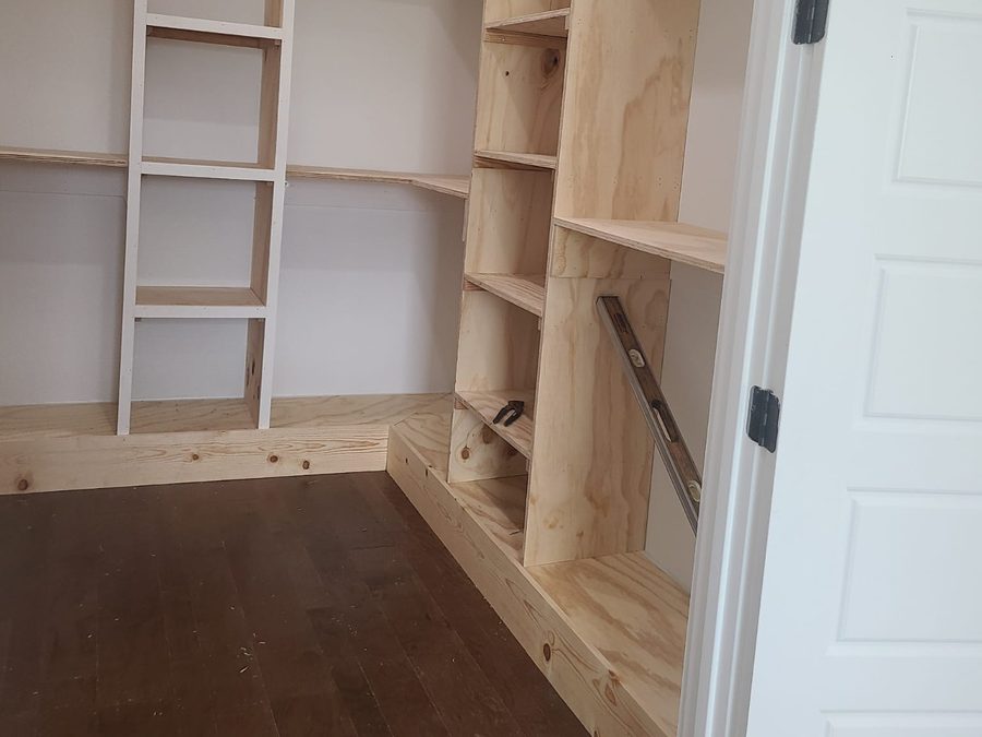 Walk-in closet with custom plywood shelving under construction