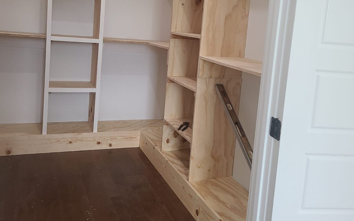 Walk-in closet with custom plywood shelving under construction