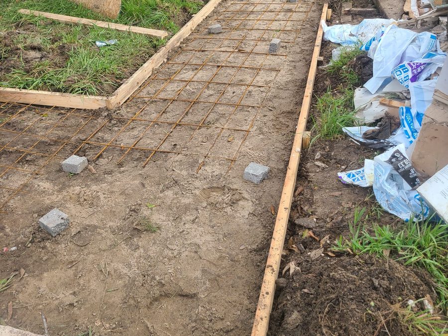 Sidewalk forms with wire mesh and spacers ready for a concrete pour