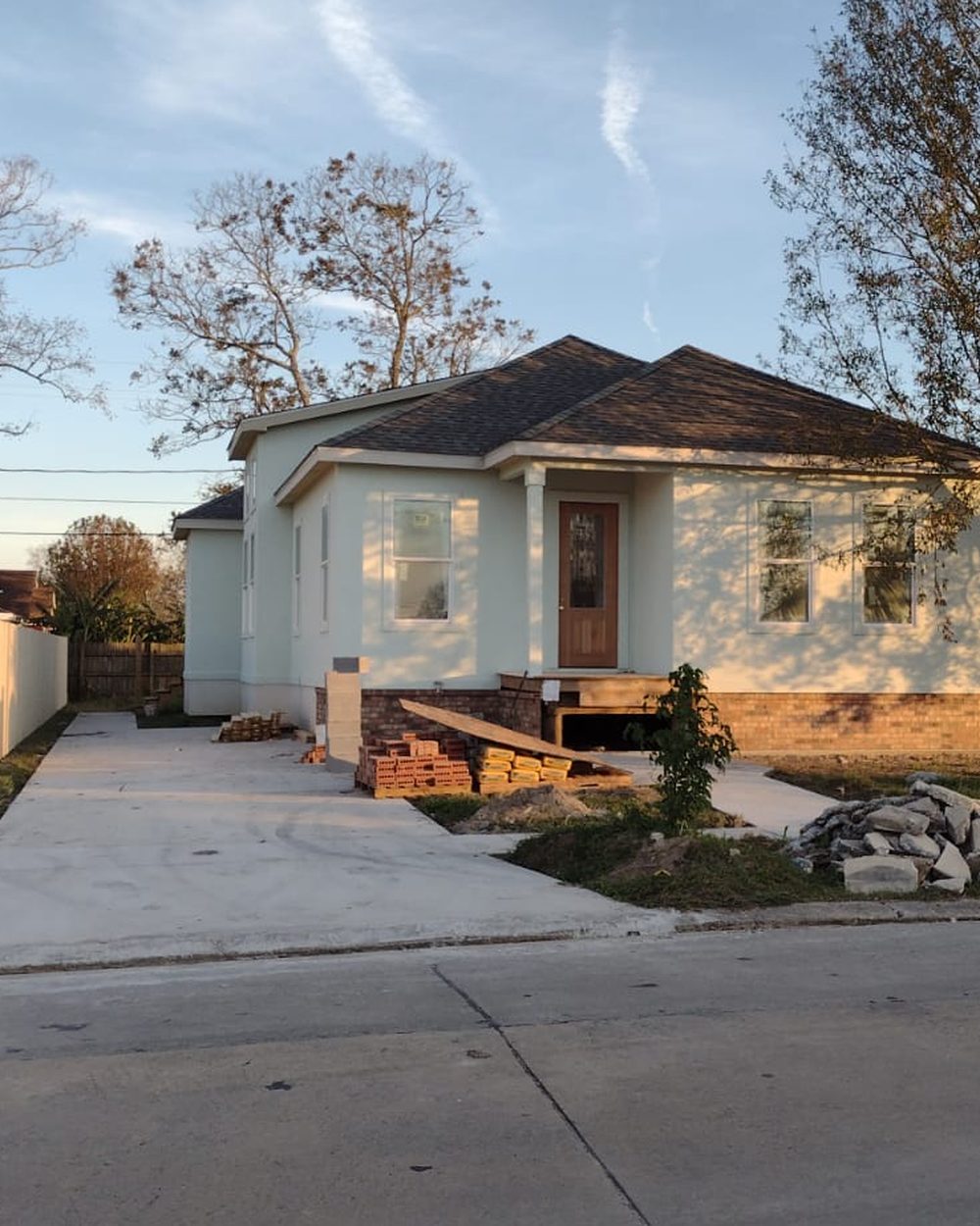 Finished mint-green home with a new concrete driveway and front walkway