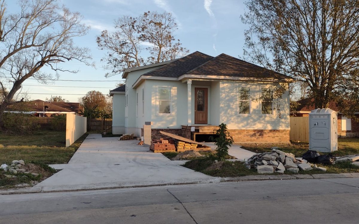 Finished mint-green home with a new concrete driveway and front walkway