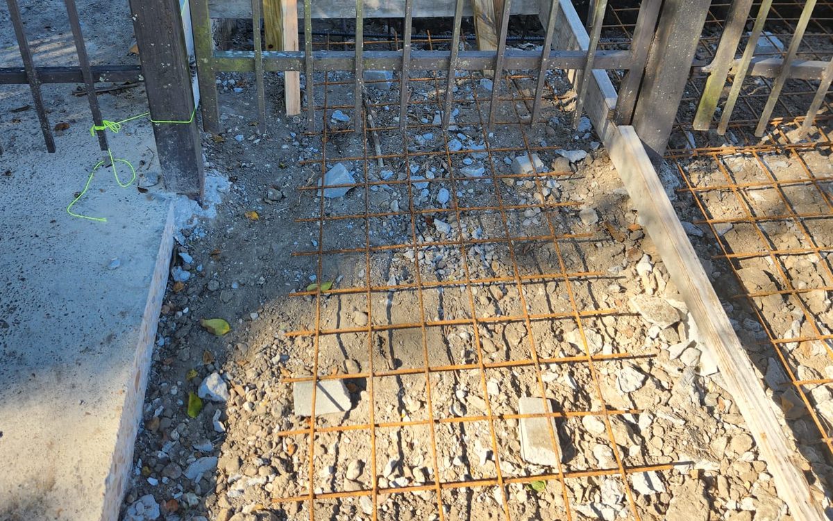 Reinforcement mesh for a new concrete entry, seen through an iron gate