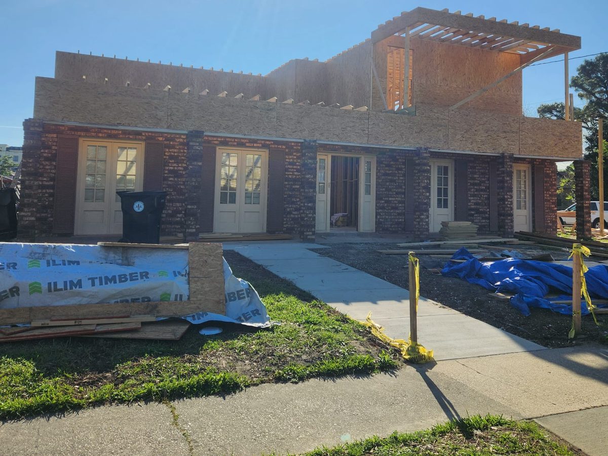 Second-story addition framed and sheathed above a brick ranch home