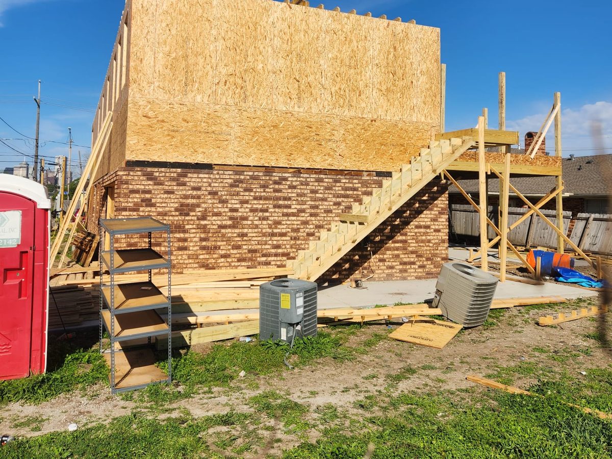 Rear of a two-story addition with new exterior stairs above a brick first floor