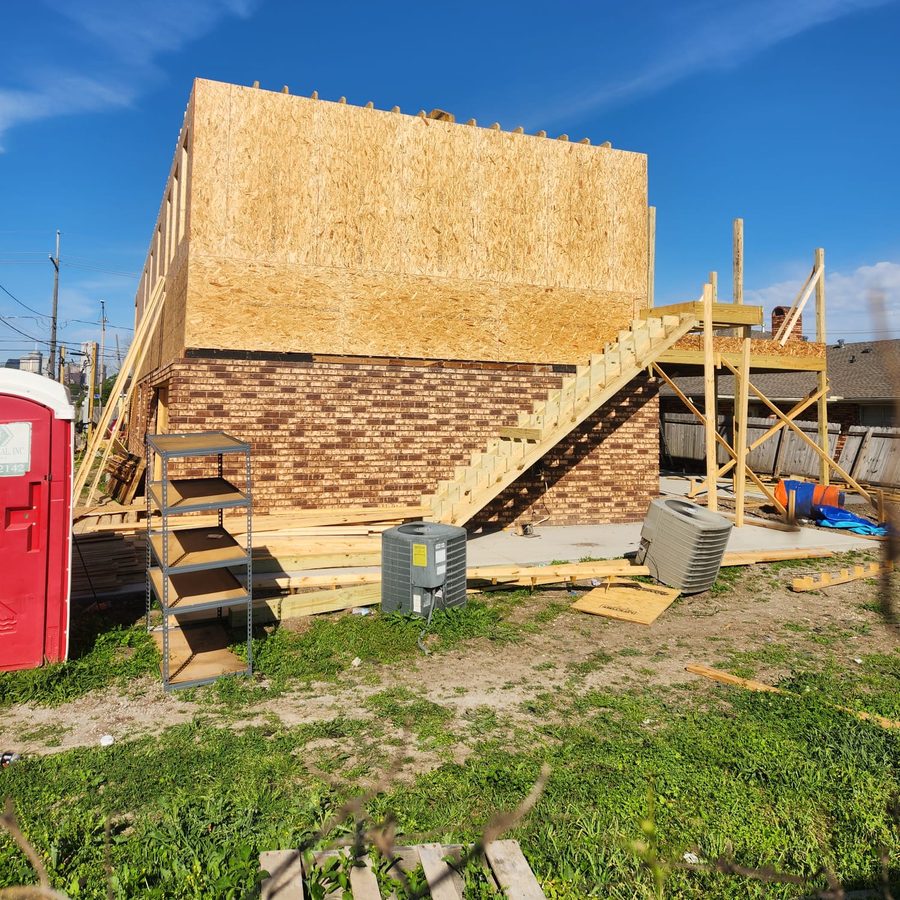 Rear of a two-story addition with new exterior stairs above a brick first floor