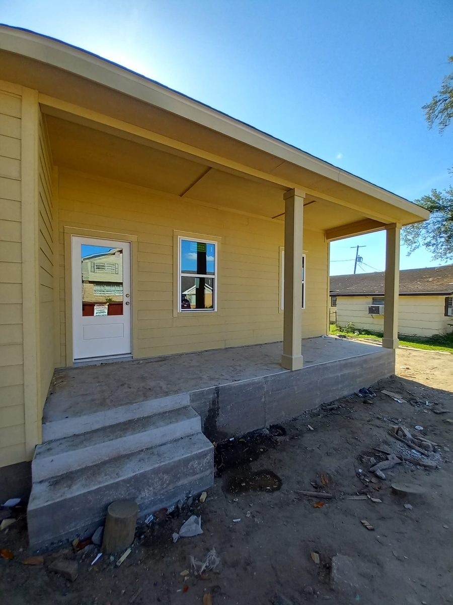 New covered porch with concrete steps and yellow lap siding