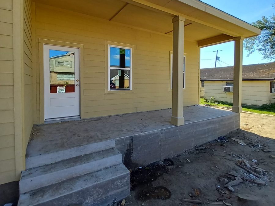 New covered porch with concrete steps and yellow lap siding