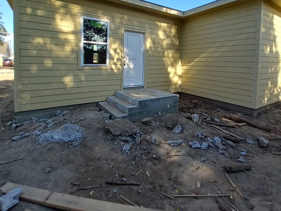 Yellow lap-sided home with new concrete entry steps