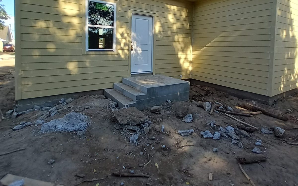 Yellow lap-sided home with new concrete entry steps